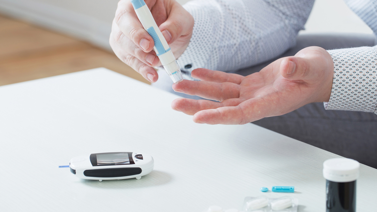 person measures blood sugar with glucometer