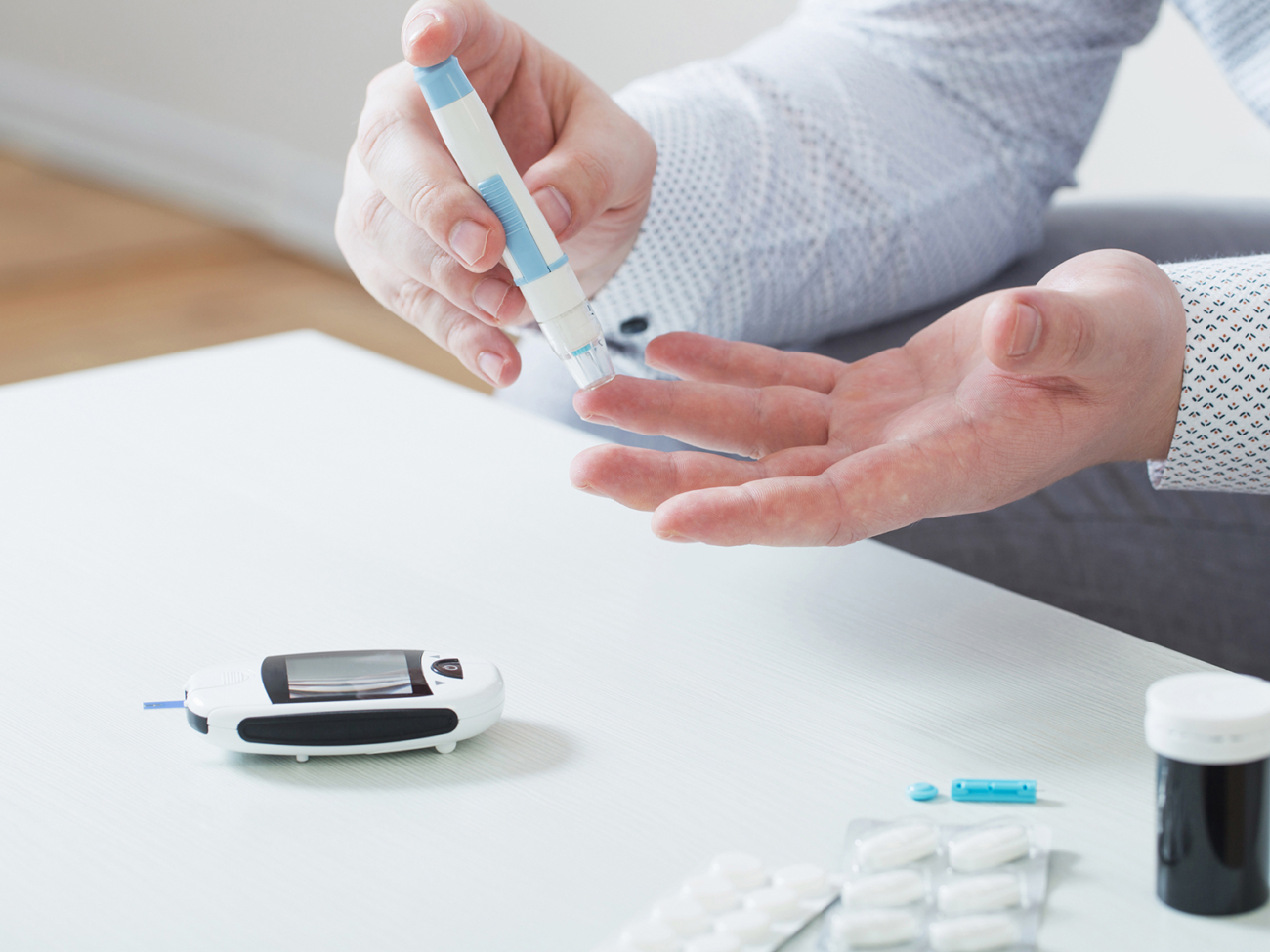 person measures blood sugar with glucometer