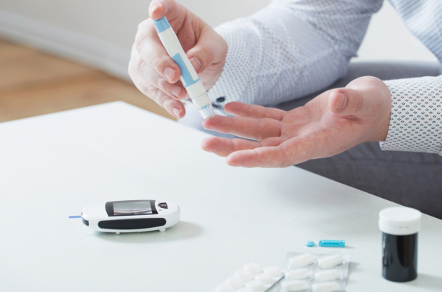 person measures blood sugar with glucometer