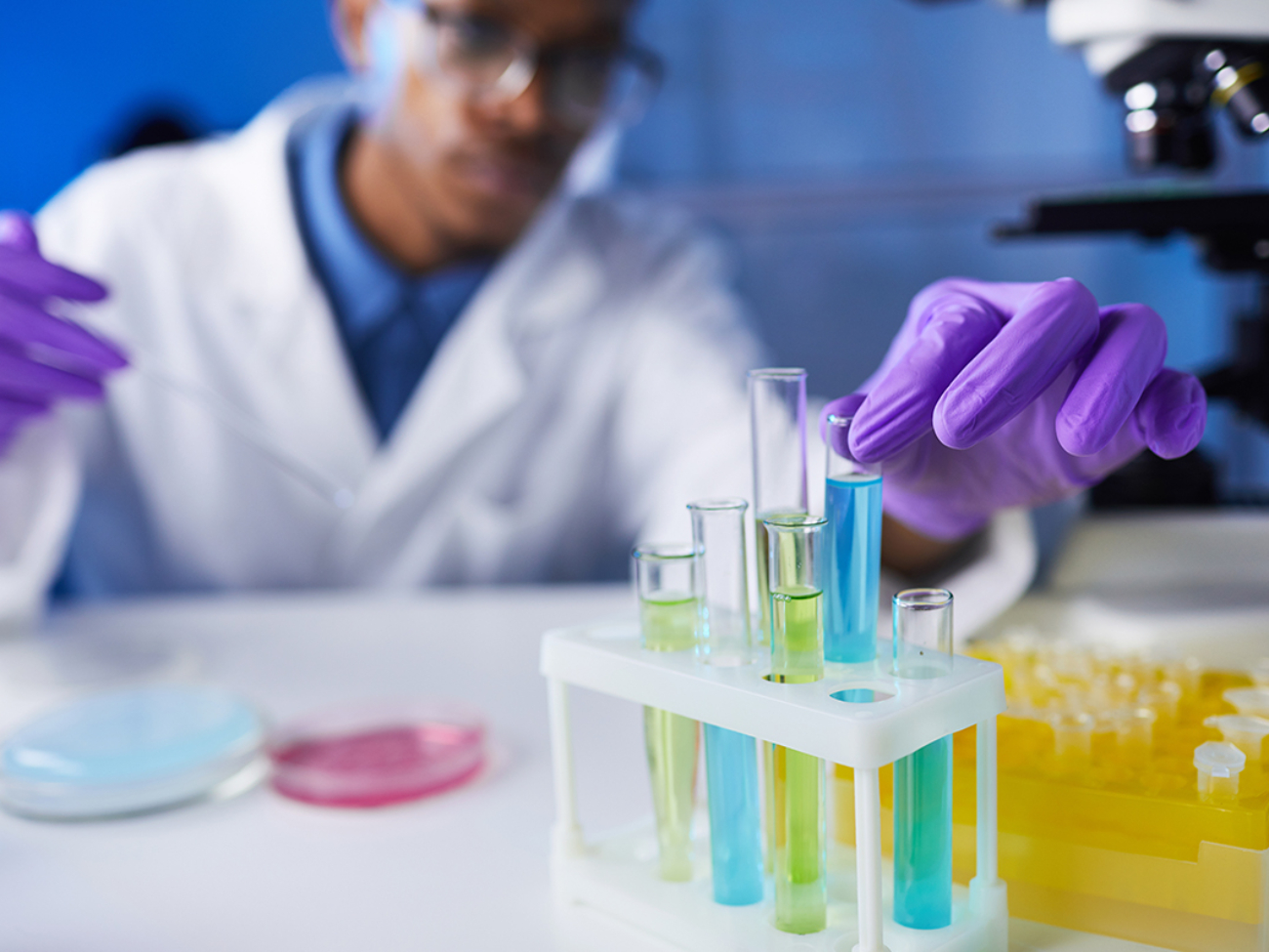 Close up of young African-American man holding test tube samples while working on medical research in laboratory, copy space